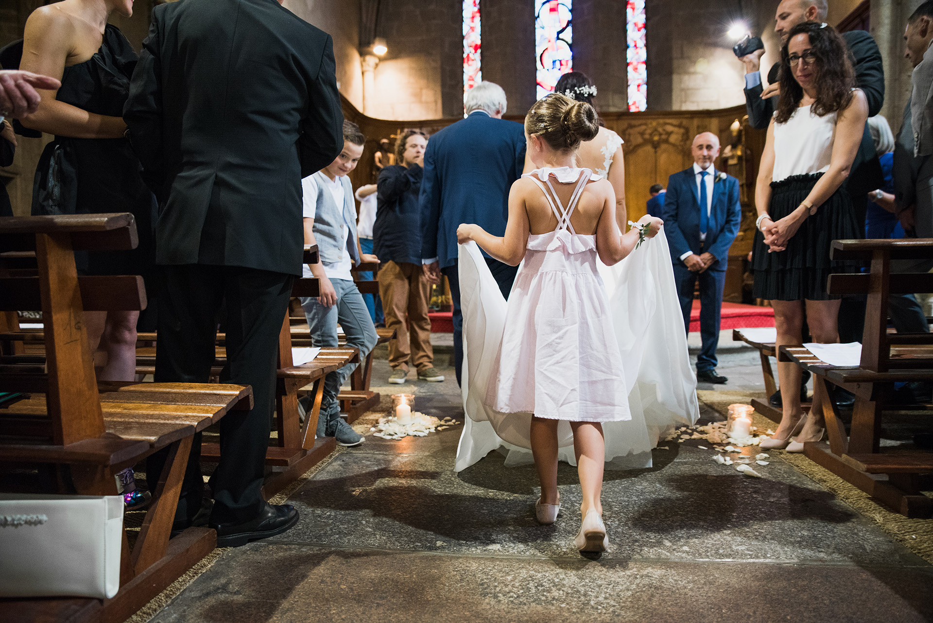 Une enfant tient la traîne de la mariée